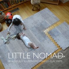 two babies are playing on the floor in front of bookshelves and stuffed animals