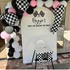 a black and white checkered theme for a first birthday party with balloons, streamers and decorations