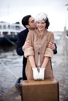 a man and woman standing next to each other holding a suitcase in front of them