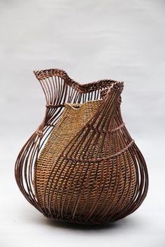 a wicker vase is sitting on a white surface with no one in the photo