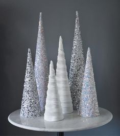 three white christmas trees sitting on top of a table