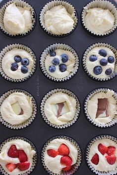 cupcakes with white frosting and strawberries in the middle are ready to be eaten