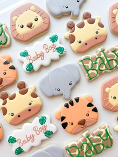 baby shower cookies decorated like animals and giraffes are displayed on a table