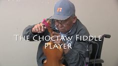 a man is holding a violin in front of his face and the words, the choctaw fiddle player