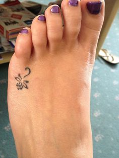 a woman's foot with a flower tattoo on it