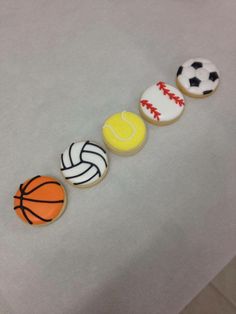 four decorated cookies in the shape of sports balls and basketballs on a white surface