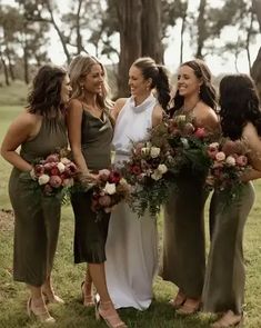 a group of women standing next to each other on top of a lush green field