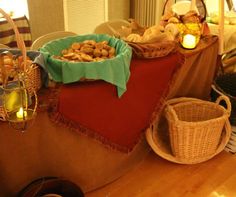 a table filled with baskets and food on top of a wooden floor