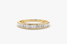 a yellow gold band with baguets and diamonds on the sides, set in 18k