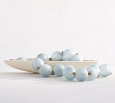 a white bowl filled with blue glass balls