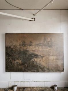 a large painting hanging on the wall in an empty room