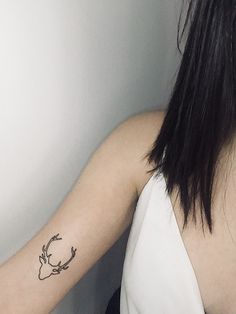 a woman's arm with a deer tattoo on the left side of her arm