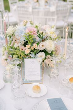 an elegant table setting with flowers and candles