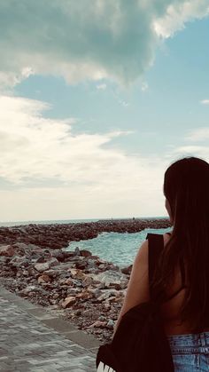 a woman is looking out at the ocean