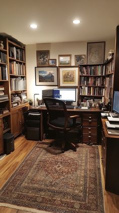 a home office with lots of bookshelves and desks in the corner, along with a rug on the floor