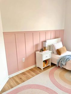 a bed room with a neatly made bed and a rug on the floor next to it