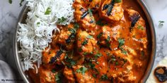 chicken tikka with rice and cilantro served in a silver bowl on a marble surface