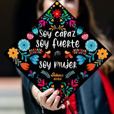 a woman wearing a graduation cap that reads soy caraza soy fuerte soy rivier