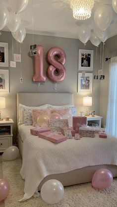 a bedroom decorated in pink and white with balloons