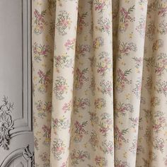 a curtain with floral print hanging from it's side