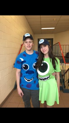 two children in costumes standing next to each other on the hallway between school hallways and staircases