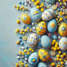 an arrangement of painted eggs and flowers on a blue background with yellow, white, and gray accents