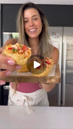 a woman holding up a piece of food in her hand