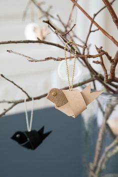 two origami birds hanging from a tree branch