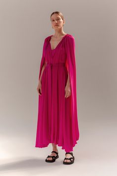 The Camila Dress by Heirlome is midi length cape dress in silk double georgette with adjustable neck ties and attached interior slip in silk charmeuse. Pre-draped Cape Evening Dress, Evening Cape Maxi Dress With Draped Sleeves, Evening Maxi Dress With Draped Sleeves And Cape Shape, Silk Cape Dress For Gala, Chiffon Maxi Dress With Cape Sleeves For Evening, Chiffon Maxi Dress With Cape Sleeves For Party, Evening Chiffon Dress With Cape Sleeves, Formal Pre-draped Cape Dress, Pink Maxi Dress With Cape Sleeves For Party