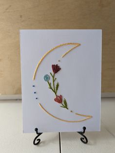 a card with flowers on it sitting on a stand