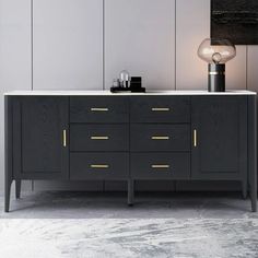 a black and white sideboard with two lights on it, next to a gray wall