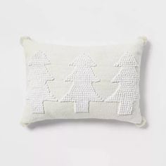 a white embroidered pillow with trees on it