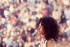 a woman holding a tennis racquet in front of a crowd