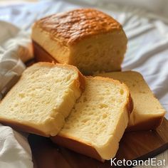 two loaves of bread sitting on top of a wooden cutting board