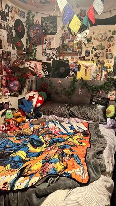 an unmade bed in a room with many pictures and toys on the wall above it