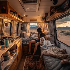 a woman sitting in the back of an rv with her dog