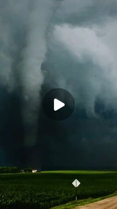 an image of a large storm coming in from the sky over a farm field and road