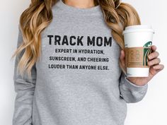 "Our funny \"Track Mama\" sweatshirt, designed for the ultimate cheerleader of the track and field world. Crafted with comfort and style in mind, this cozy sweatshirt is perfect for moms who proudly support their track stars from the sidelines. .: 50% cotton, 50% polyester .: Medium-heavy fabric (8.0 oz/yd² (271.25 g/m²) .: Loose fit .: Sewn-in label .: Runs true to size" Athletic Heather Crew Neck Sweatshirt For Workout, Track Mom Shirts Ideas, Track Shirts, Track Mom, Track Shirt, Mom Outfits Fall, Running Aesthetic, From The Sidelines, Aesthetic Things