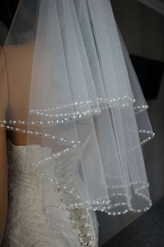 a wedding dress and veil on display in front of a mannequin's head