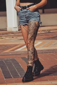 a woman in black shirt and shorts with tattoos on her legs