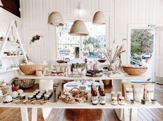 a table filled with lots of food on top of a wooden floor