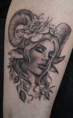 a woman's face with horns and flowers on her head is shown in this tattoo design