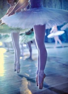 two ballerinas in tutu and leotards with their legs bent forward