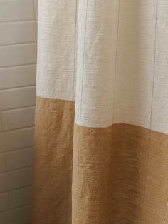 a shower curtain with brown and white stripes on the outside, hanging in a bathroom