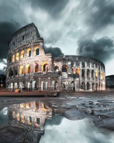 the colossion is lit up at night with its lights on and reflecting in the water