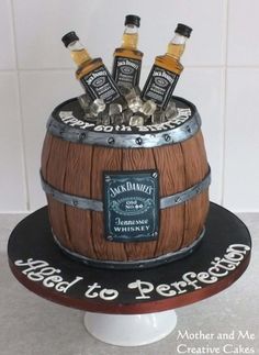 a cake made to look like a barrel with liquor bottles in it and the words happy to penfold on top