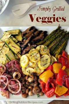 grilled veggies on a white platter with red onions and asparagus