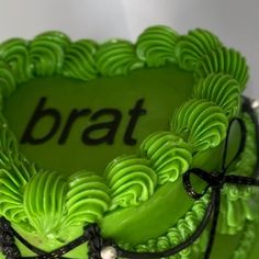 a green cake with the word brat on it's side and black ribbon around the edge