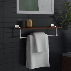 a towel rack with two towels hanging from it's sides and a mirror above it