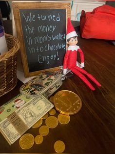 an elf is sitting next to some money and a sign